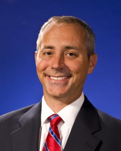 Headshot of man in suit and tie