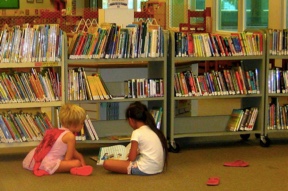Kids reading in front of a bookshelf stuffed with books