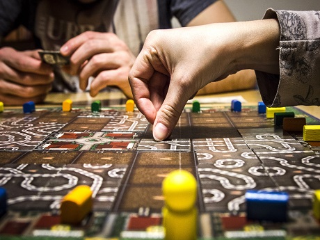 Hand moving a game piece in a board game.