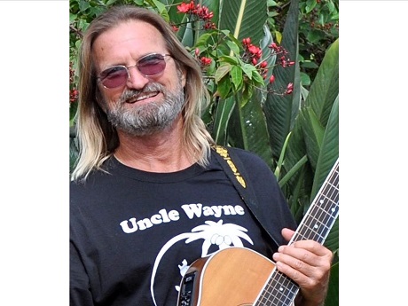 man holding a guitar with Uncle Wayne shirt