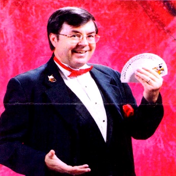 Magician Glen Bailey holding a deck of cards in left hand.