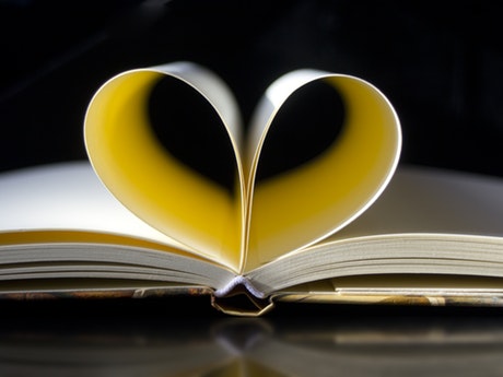 Two book pages form a heart
