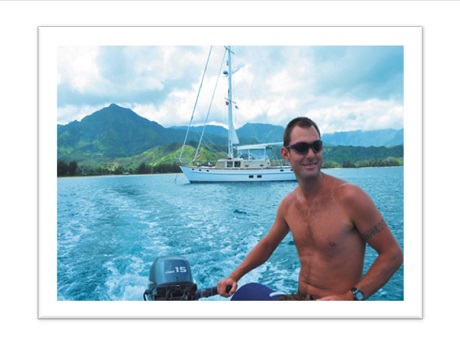 man on boat in the ocean with a Hawaiian island in the background