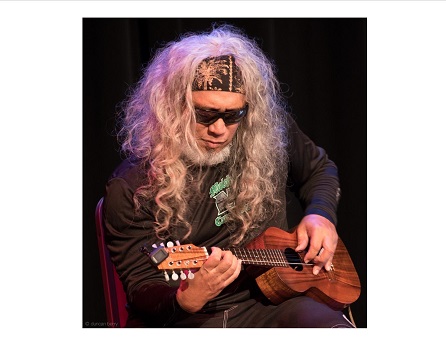 Man with long hair playing ukulele
