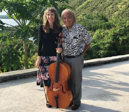 Man and woman posing in front of a cello