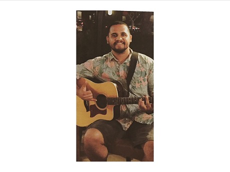 Color photo of Hawaiian-style guitar performer Jason Midro with his guitar