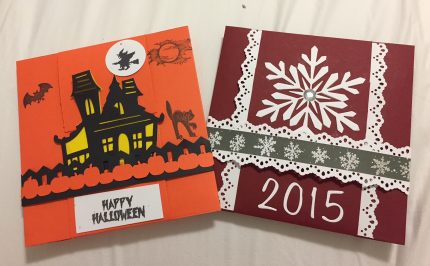 Two cards. One is orange and black with Happy Halloween and haunted house silhouette. The other is red with white lace detail and a white snowflake