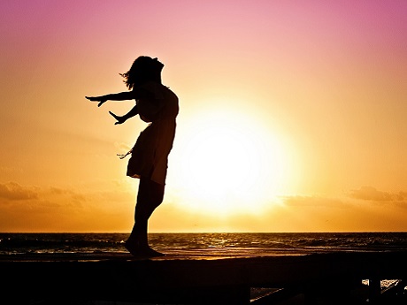 Woman breathing fresh air at the ocean