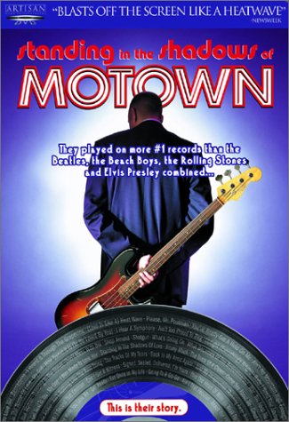 movie cover: "standing in the shadows of MOTOWN", a man from the back view holding a guitar in front of a record