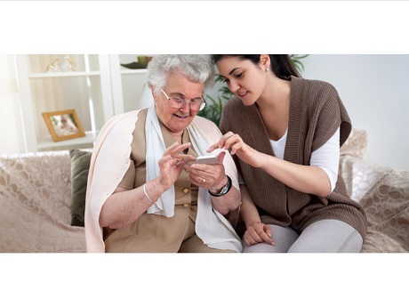 Old woman and younger woman looking at a smartphone