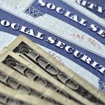 Social Security cards with several hundred dollar bills