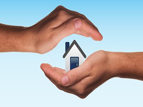 Hands holding a miniature house