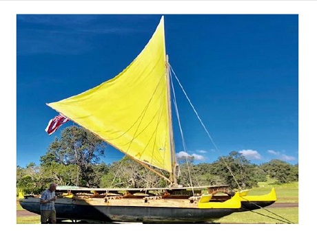 double hull canoe with a yellow sail