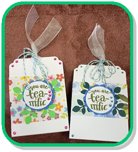 two paper craft tea totes, one pink and one blue. both have "you are tea-rrific" stickers