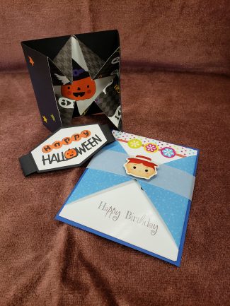 one black and orange halloween card and one blue and white card that says happy birthday