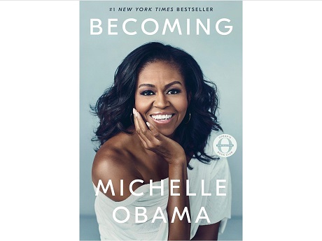 Book Cover: "BECOMING, MICHELLE OBAMA", Michelle Obama with her right hand on her cheek while smiling