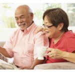 Husband and wife reading a newspaper together