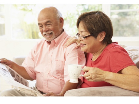 Husband and wife reading a newspaper together