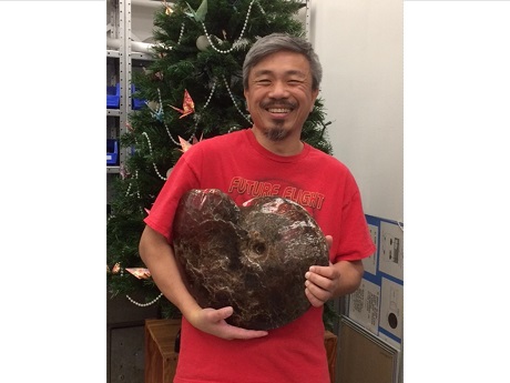 Roger Kwok holding a ammonite fossil