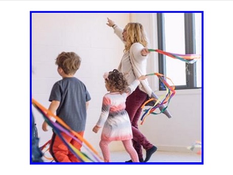 woman and two children dancing with streamers