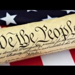Constitution Rolled up on top of the US Flag