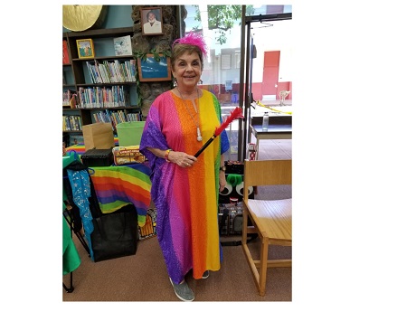 Susie Roth with a fairy wand wearing a rainbow colored dress