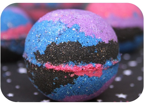 bath bomb with purple, blue, black, pink colors