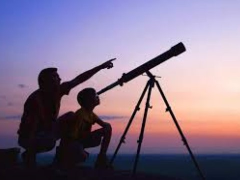 Person and child looking a telescope