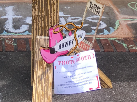 Western-themed photo props, including pink cowboy hat and wanted poster cut-out.