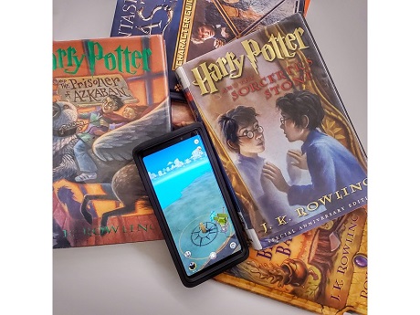 Harry Potter books with cell phone opened to Wizards unite game