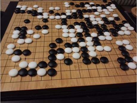 black and white go game pieces on a board