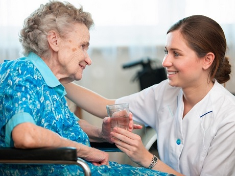 Nurse caring for elderly woman sitting in wheelchair