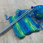 swatch with ball of yarn and knitting needles