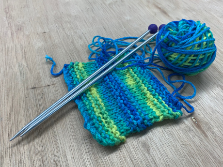 swatch with ball of yarn and knitting needles
