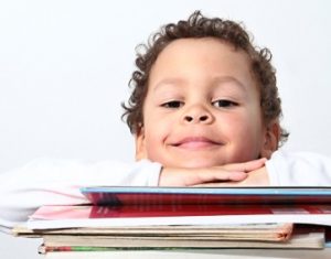 Young boy with a stack of books