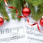 Sheet music with holiday ornaments and pine tree branches