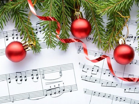Sheet music with holiday ornaments and pine tree branches
