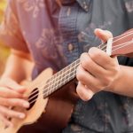 Male playing an ukulele
