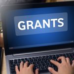 Laptop computer with the word Grants on screen
