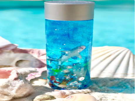 A plastic bottle filled with blue dye, glitter, and toy sea creatures