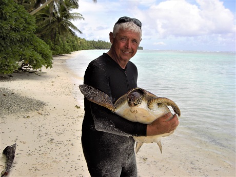 Marc Rice carrying a sea turtle at a bay