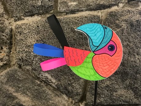 Colored parrot craft in front of a rock wall