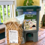 Bokashi compost in a bag, in front of a composting bin