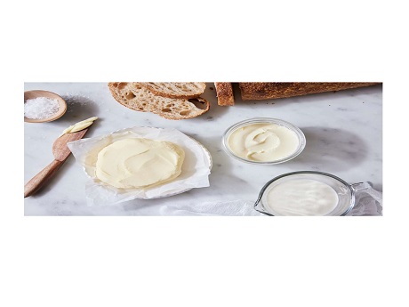 homemade butter being spread on slices of bread.