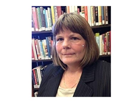 Photo of Dr. Renee DuFault in front of bookshelves