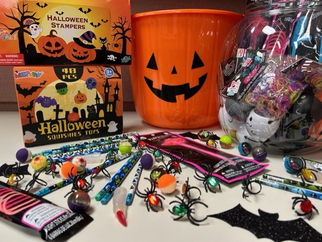 Halloween giveaways including spider rings, pencils, stampers, and squishies toys