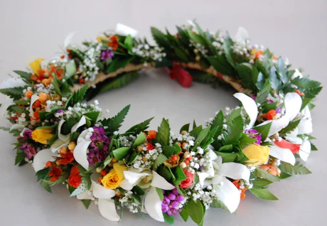 Traditional Hawaiian haku (flower crown) made with various flowers and leaves.