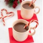 Two cups of hot cocoa with some candy canes