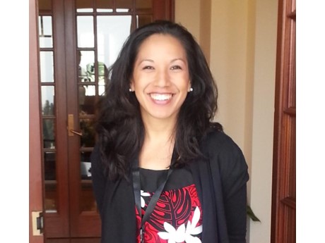 A smiling woman with in a red, white and black top.