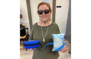 Photo of Margaret Bourget holding sewing kit and small pillow